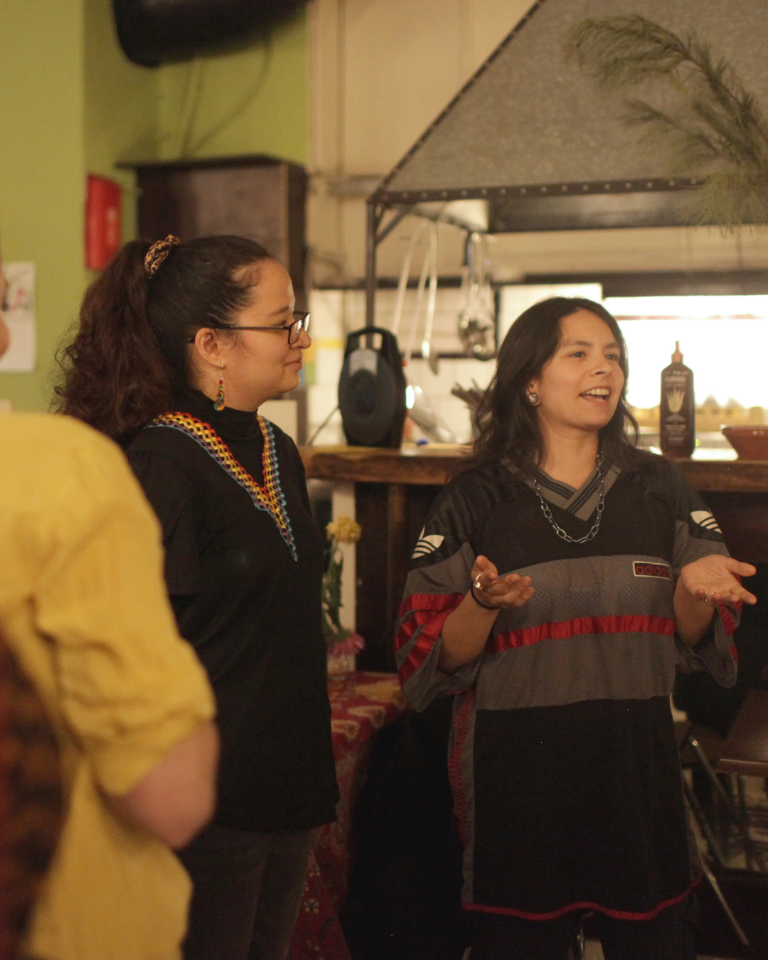 Next to a kitchen, one person explains their point ot the group